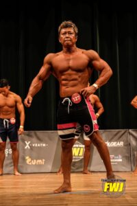 FWJ沖縄大会のステージでポージングするパーソナルジムイチ代表の長崎