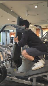 ユウタがVスクワットマシンを使用してトレーニング 後ろ向き