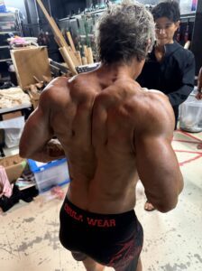 強みである広背筋・肩の張り出しを見せるバックポーズ